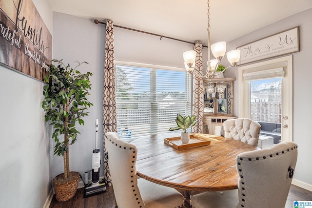 dining room with dark hardwood / wood-style floors and a chandelier