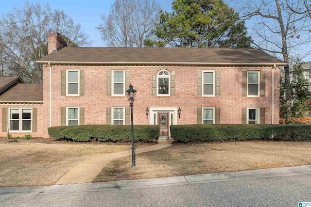 colonial inspired home featuring a front lawn