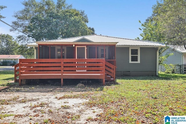 back of property featuring a sunroom, a yard, and a deck