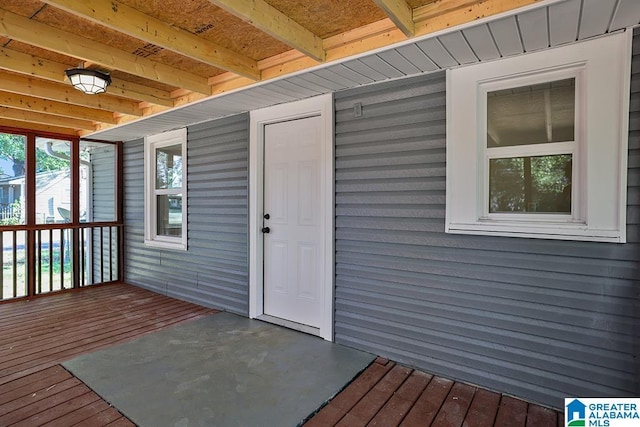 view of exterior entry with a wooden deck