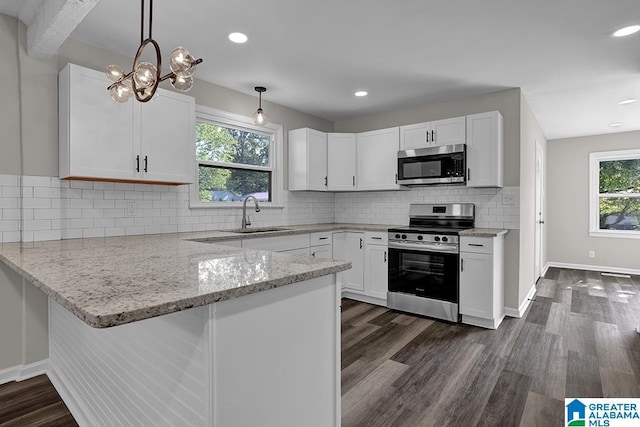 kitchen featuring white cabinetry, stainless steel appliances, sink, and hanging light fixtures