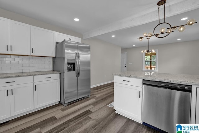 kitchen with appliances with stainless steel finishes, pendant lighting, white cabinets, light stone counters, and beam ceiling