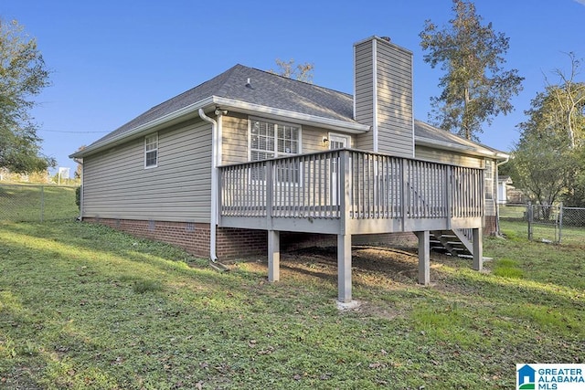 rear view of house with a wooden deck and a yard