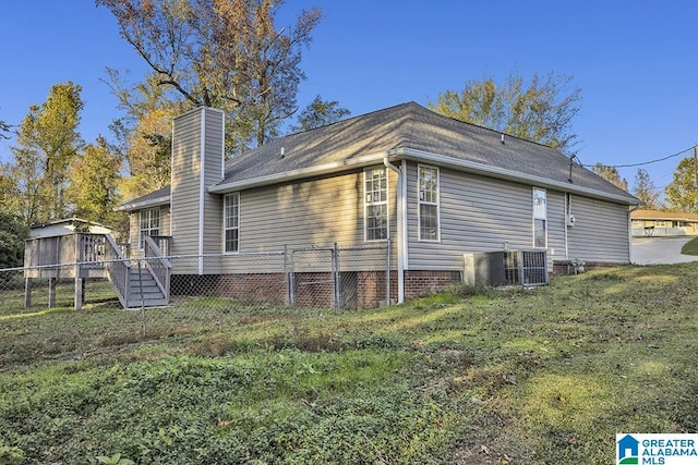 back of house featuring a yard and cooling unit