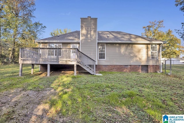 back of property featuring a deck and a lawn