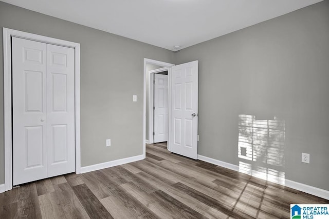 unfurnished bedroom featuring light hardwood / wood-style floors and a closet