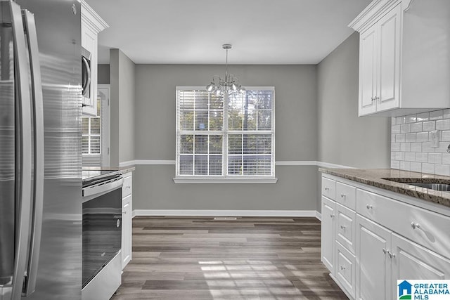 kitchen featuring sink, white cabinetry, wood-type flooring, appliances with stainless steel finishes, and backsplash