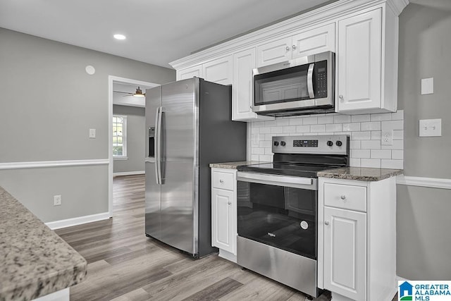 kitchen featuring backsplash, appliances with stainless steel finishes, light wood-type flooring, and white cabinets