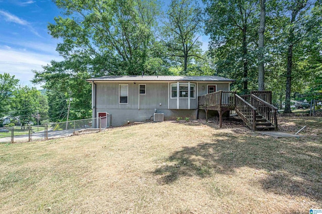 rear view of property with central AC unit, a yard, and a deck