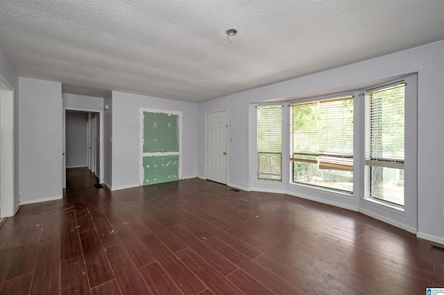 empty room featuring dark hardwood / wood-style floors and a textured ceiling