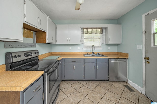 kitchen with stainless steel appliances, gray cabinets, sink, and a wealth of natural light