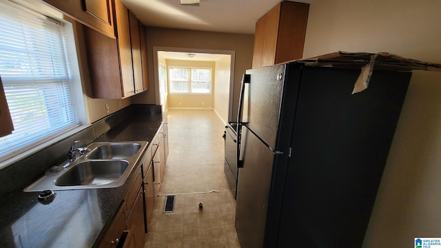 kitchen featuring black fridge and sink