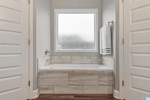 bathroom with a relaxing tiled tub