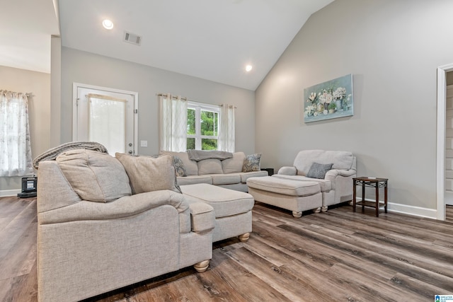 living room with dark wood-type flooring and high vaulted ceiling