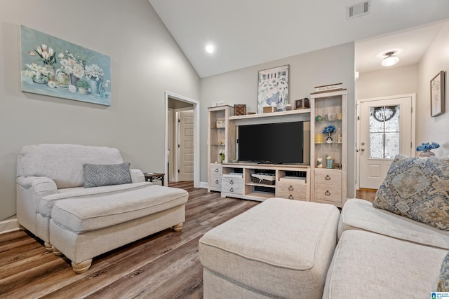 living room featuring wood-type flooring and high vaulted ceiling