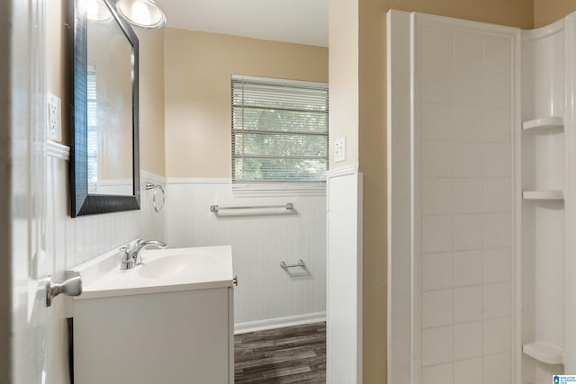 bathroom with hardwood / wood-style flooring, vanity, and walk in shower