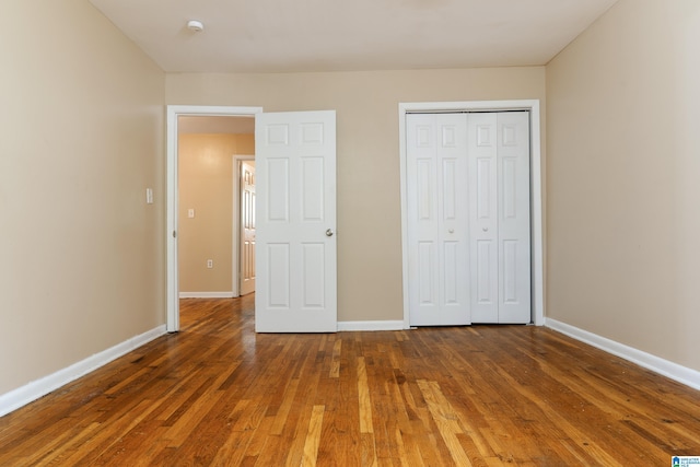 unfurnished bedroom featuring dark hardwood / wood-style flooring and a closet