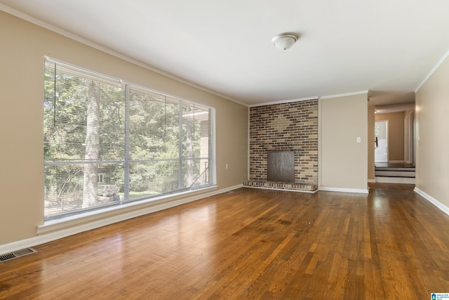 unfurnished living room with a fireplace, ornamental molding, and dark hardwood / wood-style floors