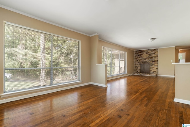 unfurnished living room with ornamental molding, a brick fireplace, and dark wood-type flooring