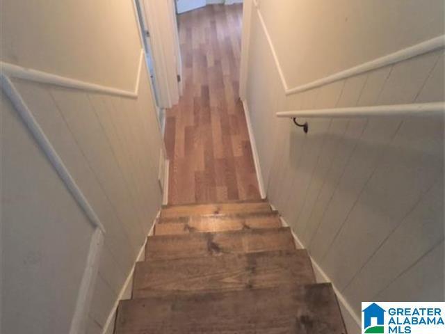 2838 Micmac Dr, Birmingham, AL 35215 - stairs featuring a wainscoted wall, a decorative wall, and wood finished floors