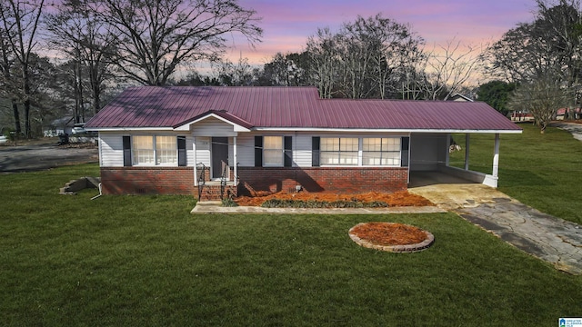 single story home featuring a carport and a lawn