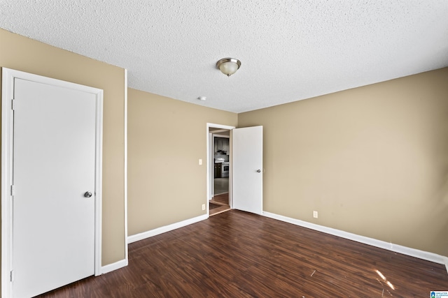 unfurnished bedroom with dark hardwood / wood-style floors and a textured ceiling