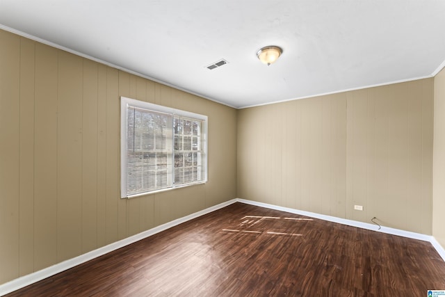 empty room with crown molding and hardwood / wood-style floors