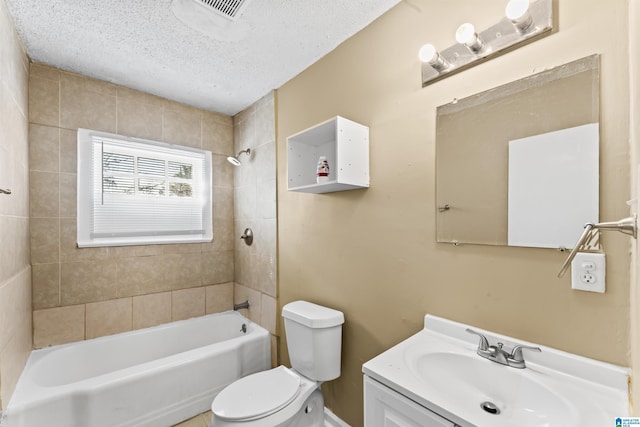 full bathroom with tiled shower / bath, vanity, toilet, and a textured ceiling