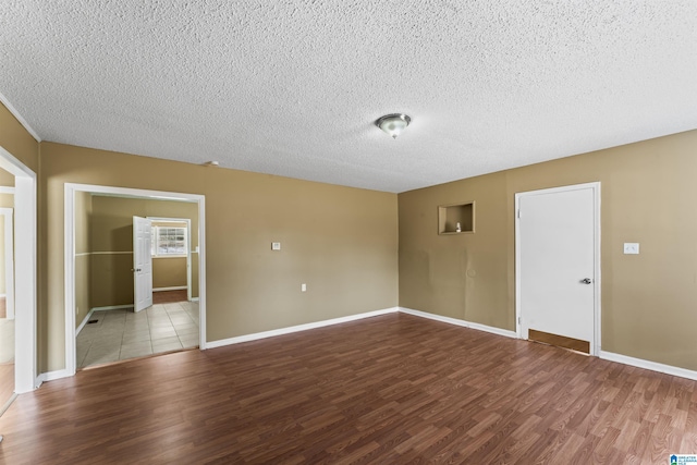 unfurnished room with a textured ceiling and light wood-type flooring