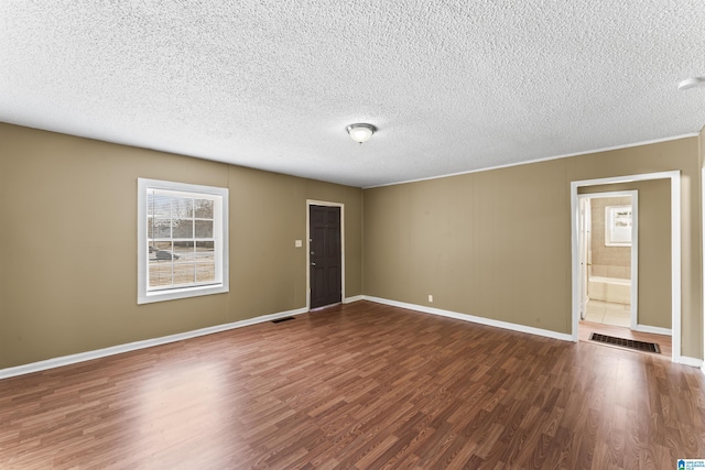 unfurnished room featuring hardwood / wood-style floors and a textured ceiling