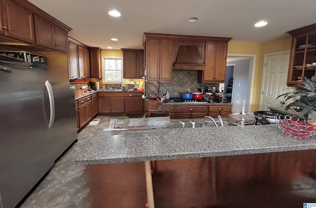 kitchen with tasteful backsplash, custom exhaust hood, and stainless steel appliances