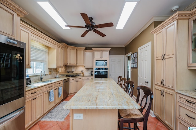 kitchen with stainless steel appliances, a kitchen island, sink, and a breakfast bar area