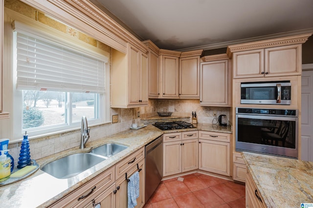 kitchen featuring light brown cabinetry, tasteful backsplash, sink, light tile patterned floors, and stainless steel appliances