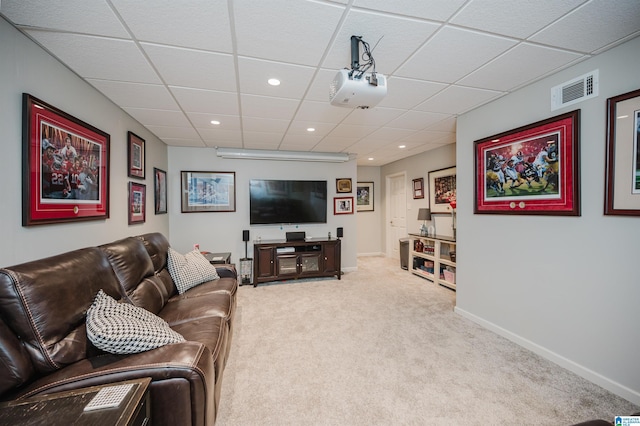 carpeted living room with a drop ceiling