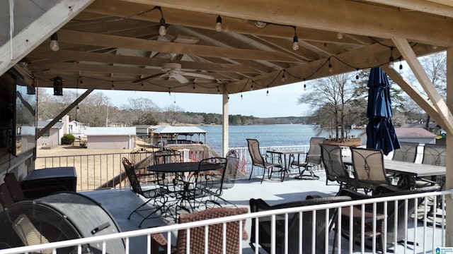 wooden terrace featuring a gazebo, a water view, and ceiling fan