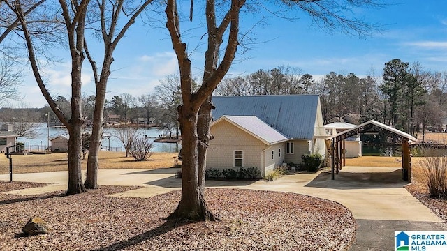 view of home's exterior featuring a carport and a water view