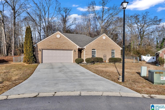 view of front of home with an attached garage, brick siding, fence, concrete driveway, and a gate