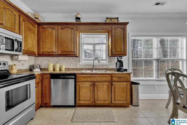 kitchen featuring stainless steel appliances, visible vents, a sink, and ornamental molding