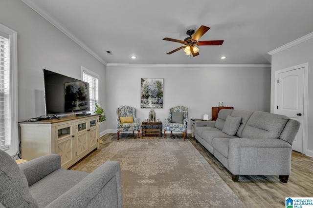 living area with crown molding, recessed lighting, baseboards, and light wood-style floors