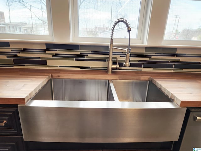 details featuring tasteful backsplash, sink, and butcher block countertops