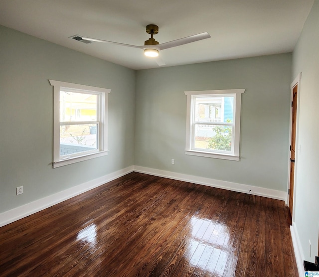 spare room with dark hardwood / wood-style flooring and ceiling fan