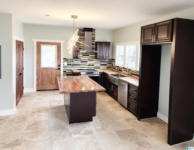 kitchen with decorative light fixtures, backsplash, stainless steel appliances, dark brown cabinets, and wall chimney exhaust hood