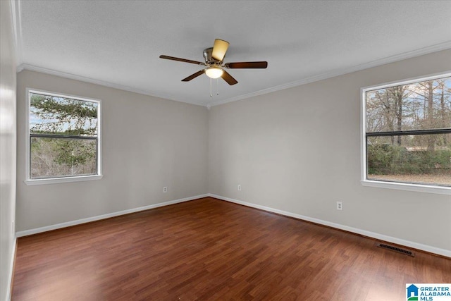 empty room with wood-type flooring, plenty of natural light, and crown molding