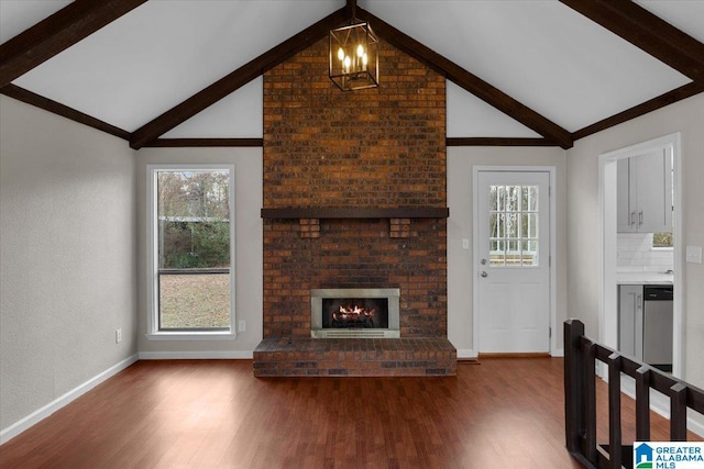 unfurnished living room featuring beamed ceiling, a chandelier, high vaulted ceiling, a brick fireplace, and hardwood / wood-style flooring