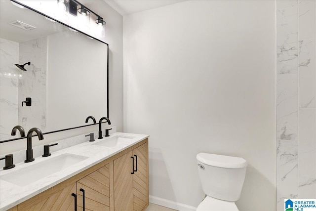 bathroom featuring vanity, toilet, and tiled shower