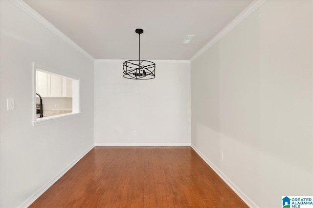 unfurnished dining area featuring hardwood / wood-style flooring, crown molding, and a notable chandelier