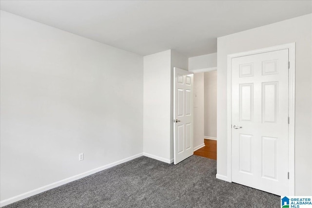 unfurnished bedroom featuring dark carpet