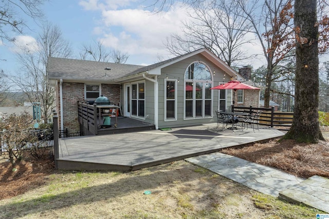 rear view of property featuring a wooden deck