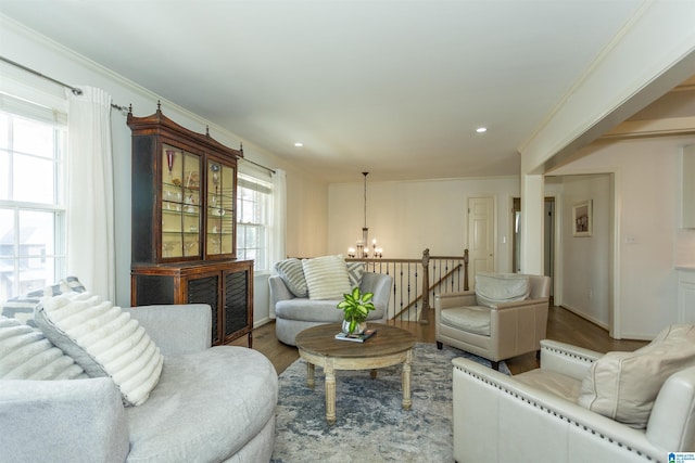 living room featuring hardwood / wood-style flooring, crown molding, and an inviting chandelier