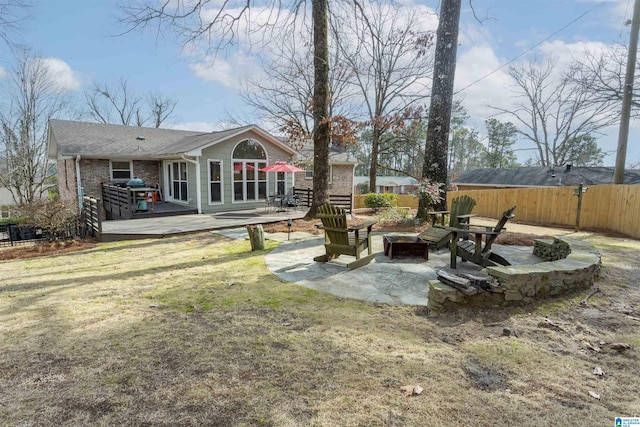 view of yard with an outdoor fire pit, a deck, and a patio